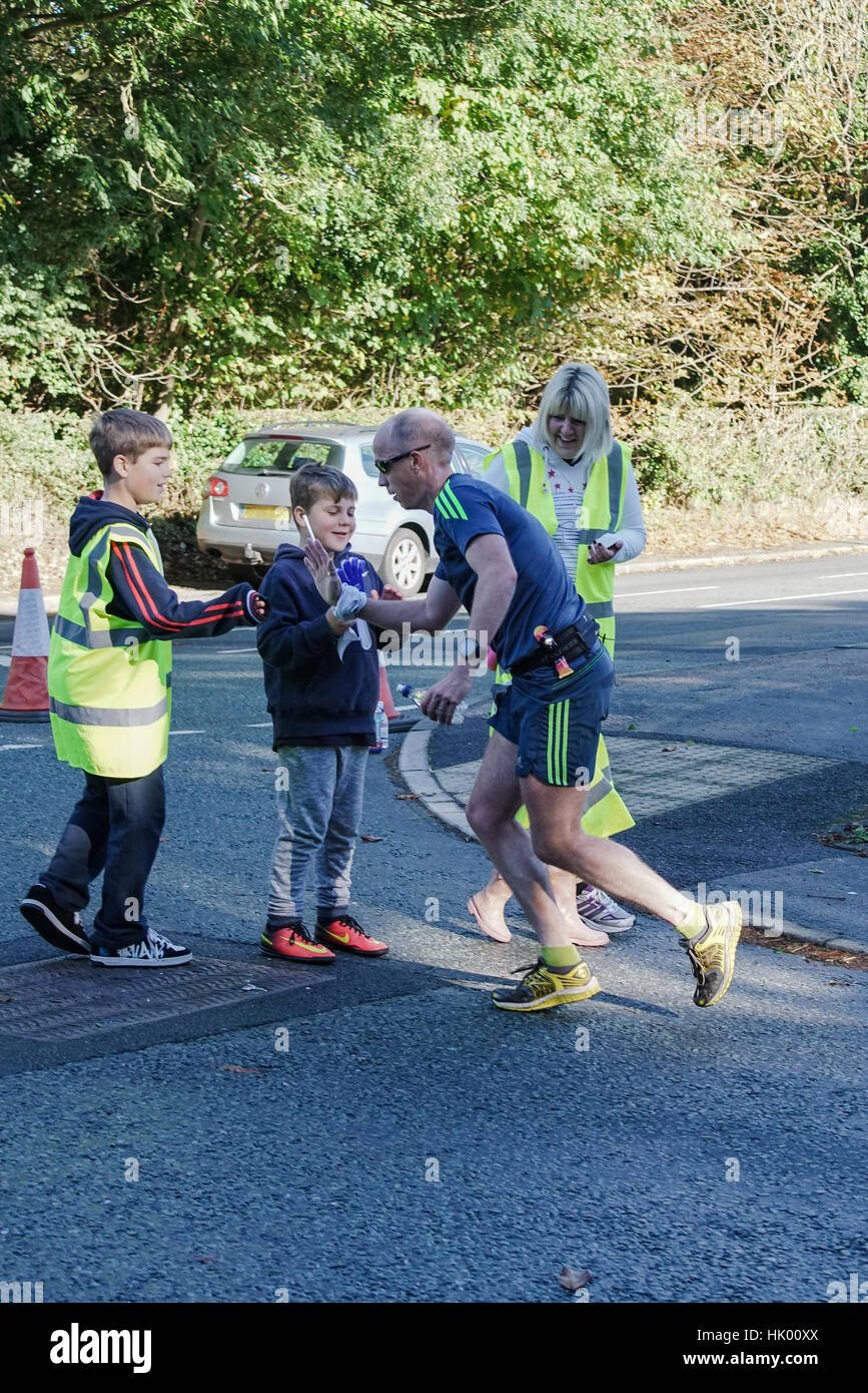 A runner high fives his supporters in the Chester Marathon Stock Photo