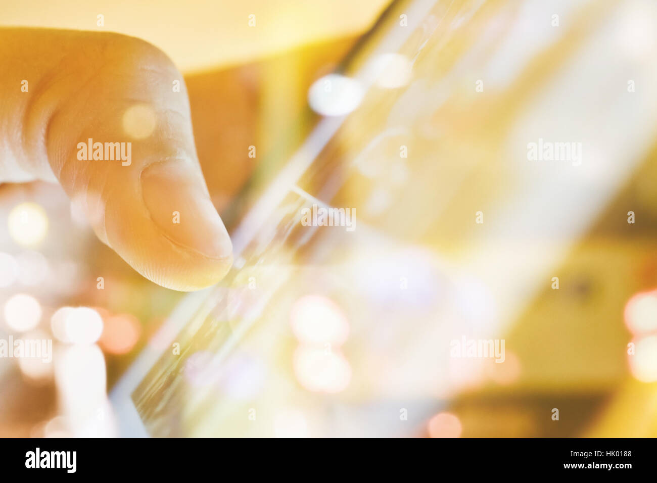 close up of Male fingers touching tablet screen double exposure and defocused city night light background. Stock Photo