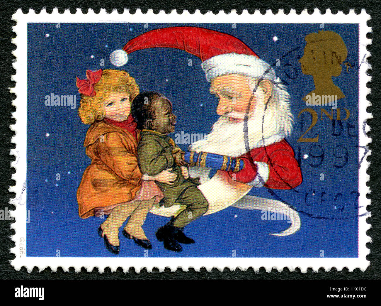 GREAT BRITAIN - CIRCA 1997: A used postage stamp from the UK, depicting an illustration of two children sitting on the lap of Father Christmas, circa  Stock Photo