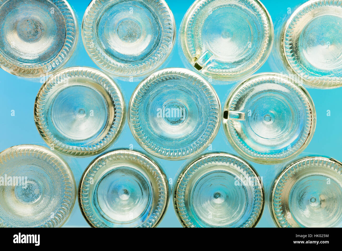 Bottoms of empty glass bottles on blue background Stock Photo - Alamy