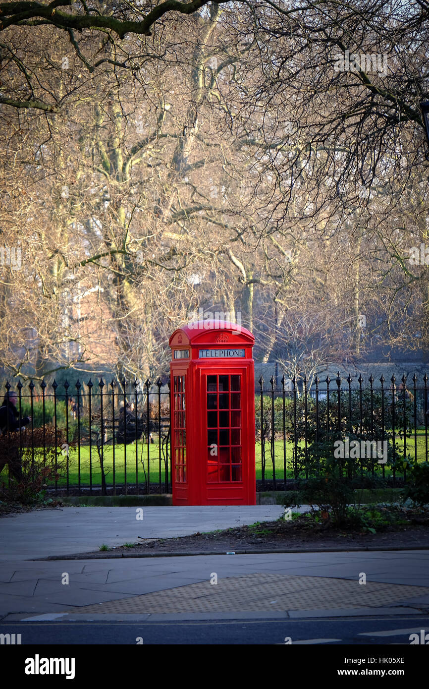 An old fashioned red telephone box stands on a street corner in London Stock Photo