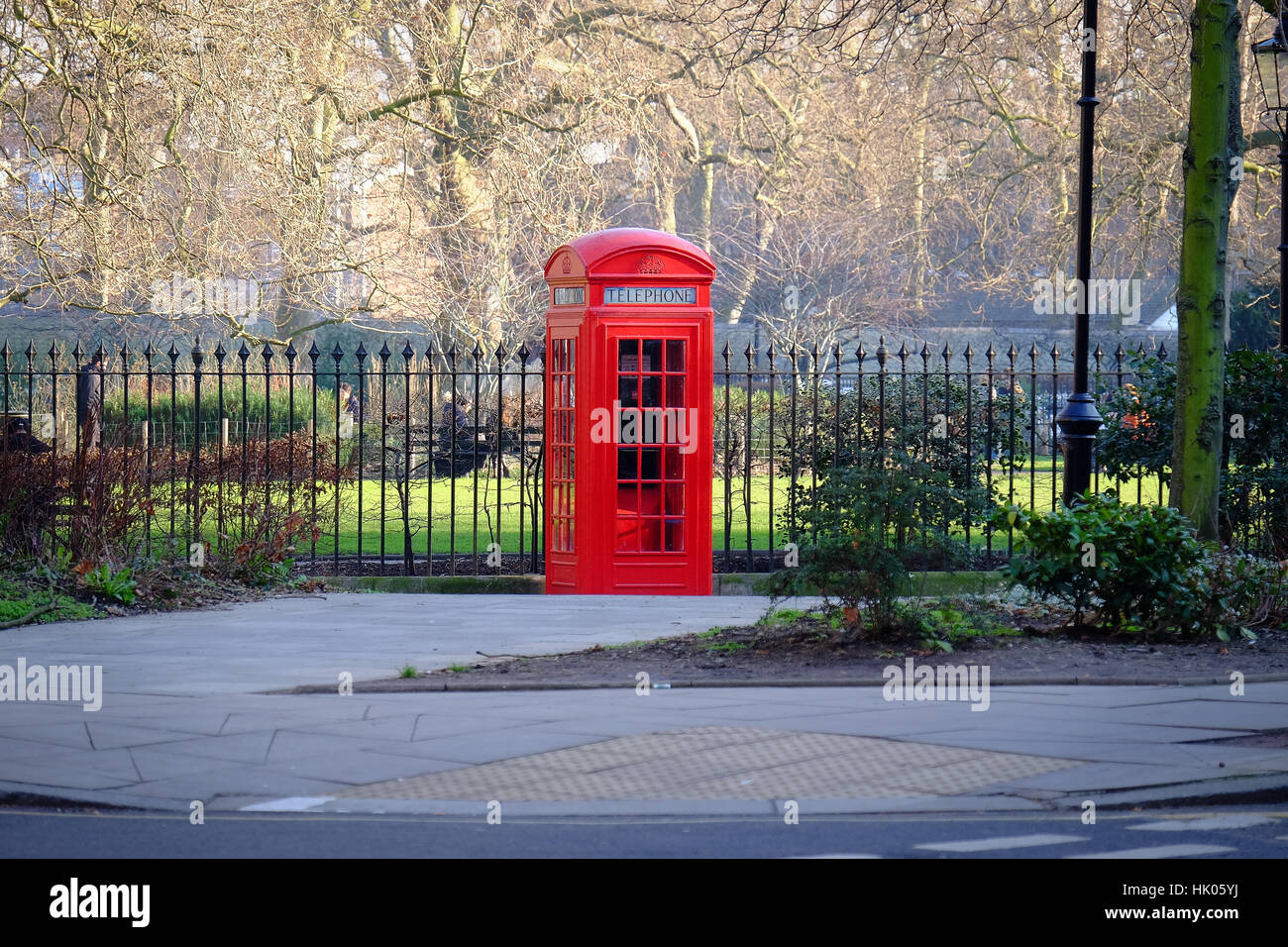 An old fashioned red telephone box stands on a street corner in London