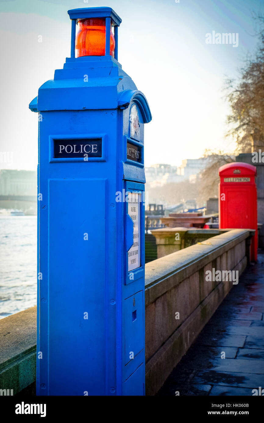 An old fashioned police box and telephone box stand along London's River Thames Stock Photo