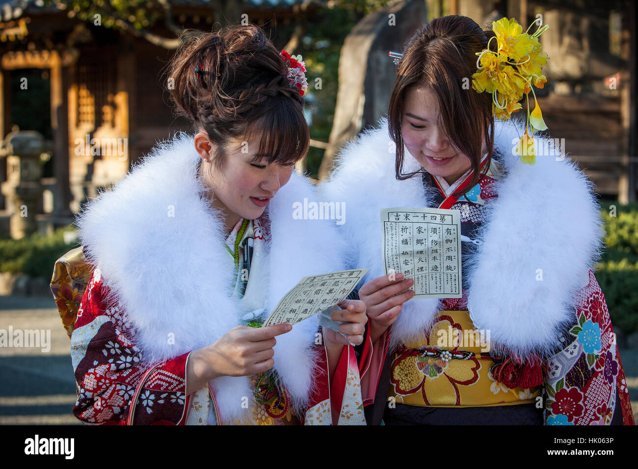 Women in furisode kimono reading their omikuji paper oracle, Seijin no hi day, celebration of the coming of age, second Monday of January, in Asakusa Stock Photo