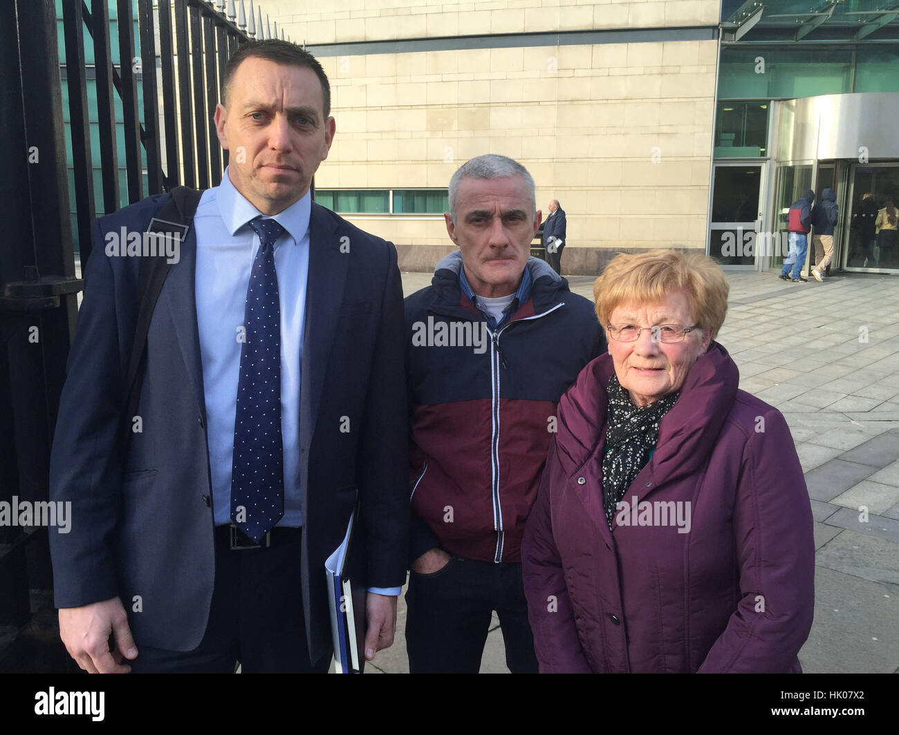 (Left to right) Family solicitor Padraig O Muirigh with Henry Thornton's son Damien and widow Mary outside Belfast Coroner's court, where a coroner has named a British soldier who shot dead father of six Henry Thornton outside a Belfast police station after mistaking a van backfiring for a gun attack. Stock Photo