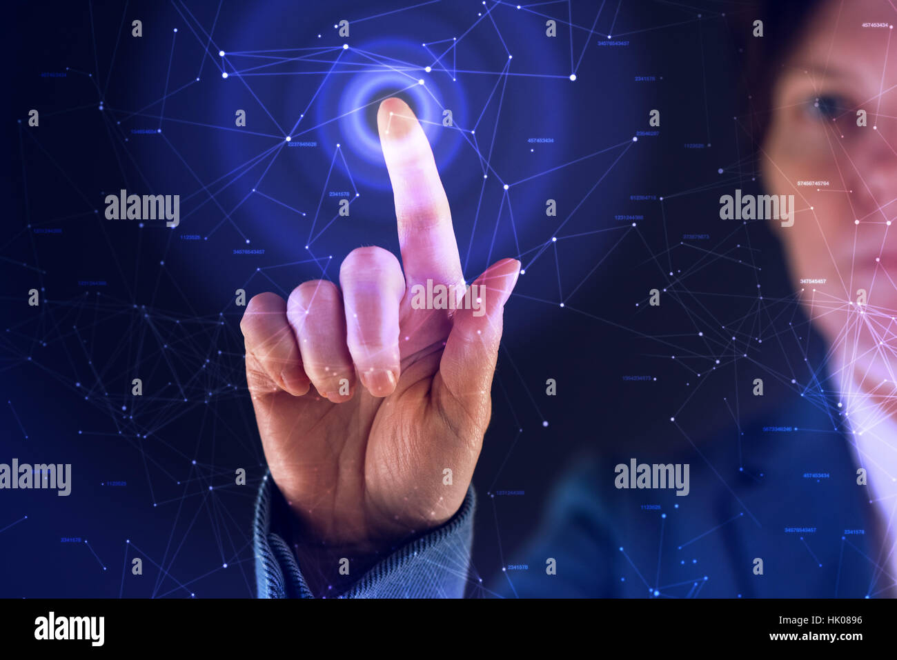 Businesswoman working in futuristic cyberspace hightech environment, hand pushing interface button Stock Photo