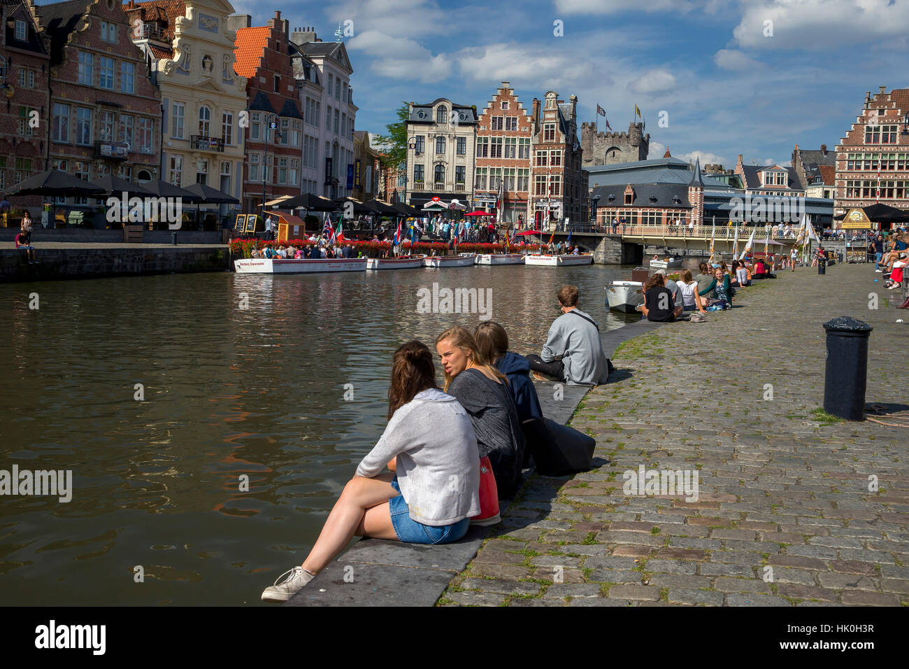 Young people enjoy summer sunshine along the Graslei and Korenlei, Ghent, Belgium Stock Photo