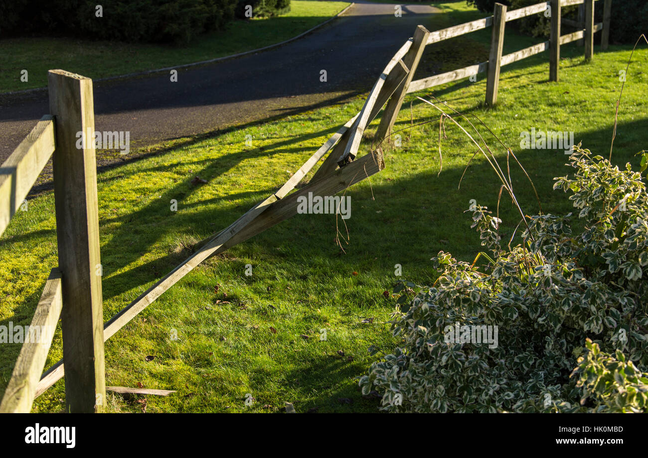 Wooden fence broken after being hit by a large van. Stock Photo