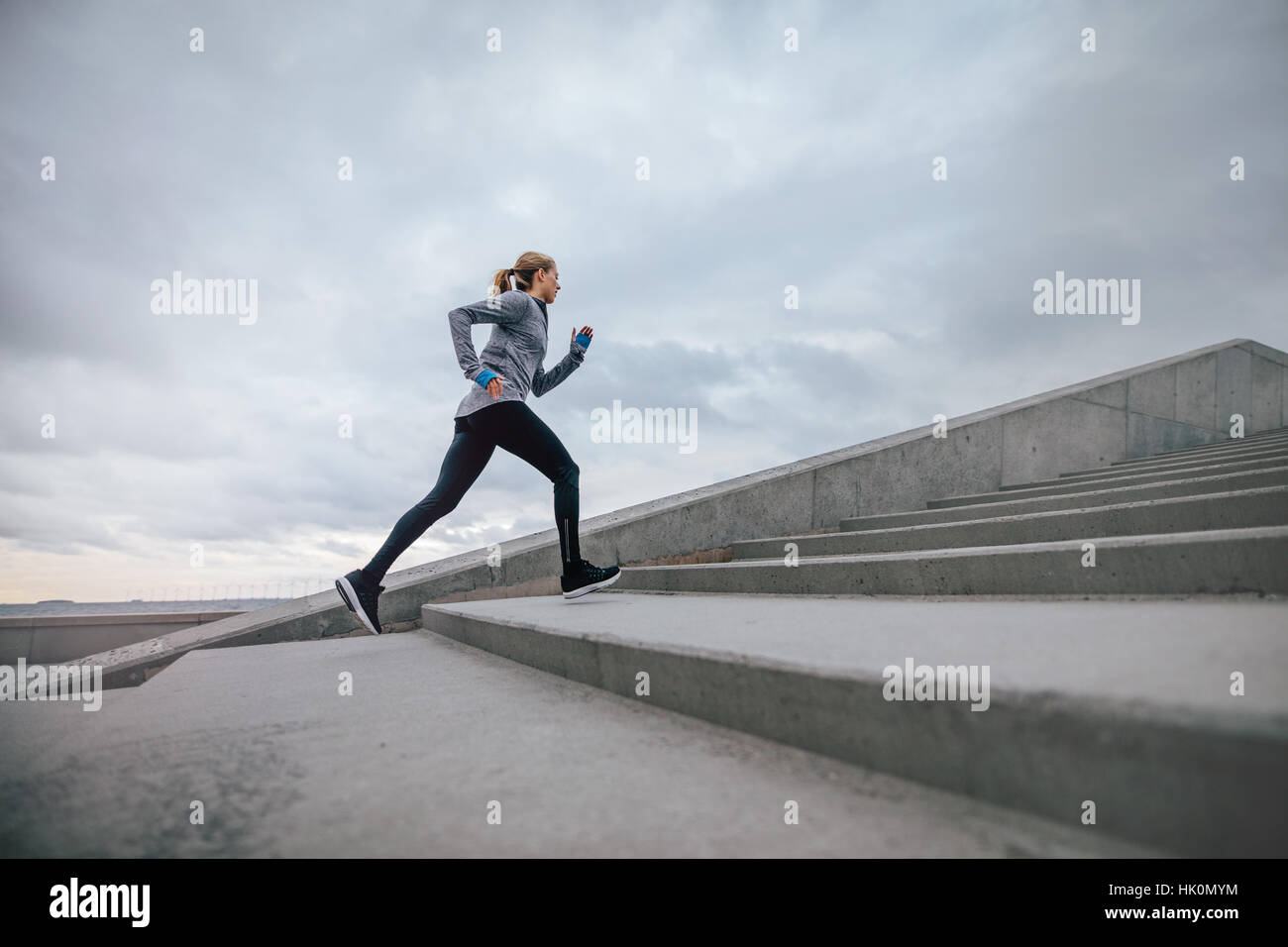 Full length shot of woman running on steps outdoors. fitness female exercising in morning. Stock Photo