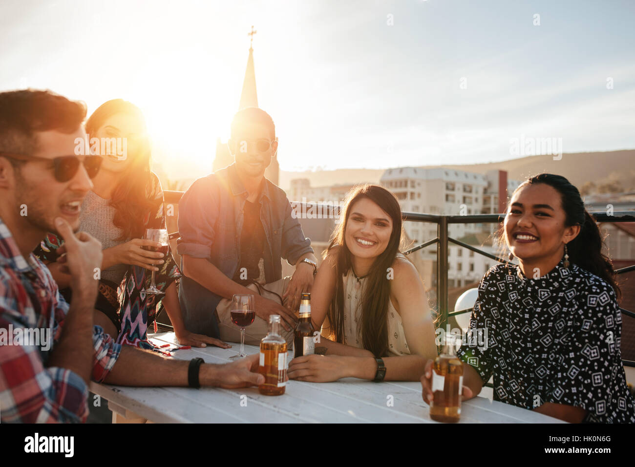 Group of happy young people having a rooftop party. Friends enjoying party with drinks. Stock Photo