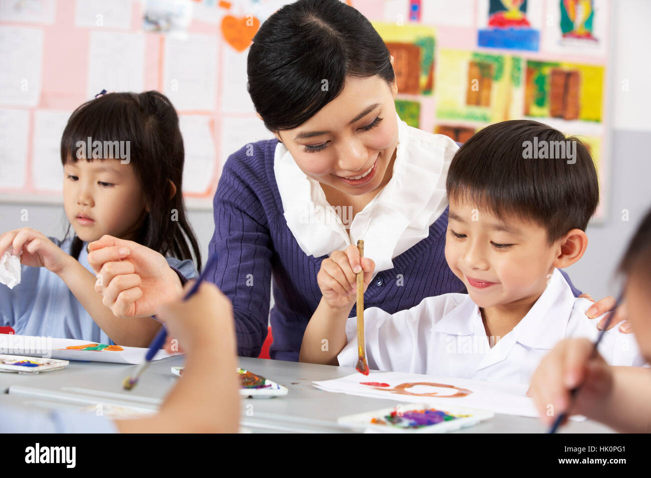 Teacher Helping Students During Art Class In Chinese School Classroom ...