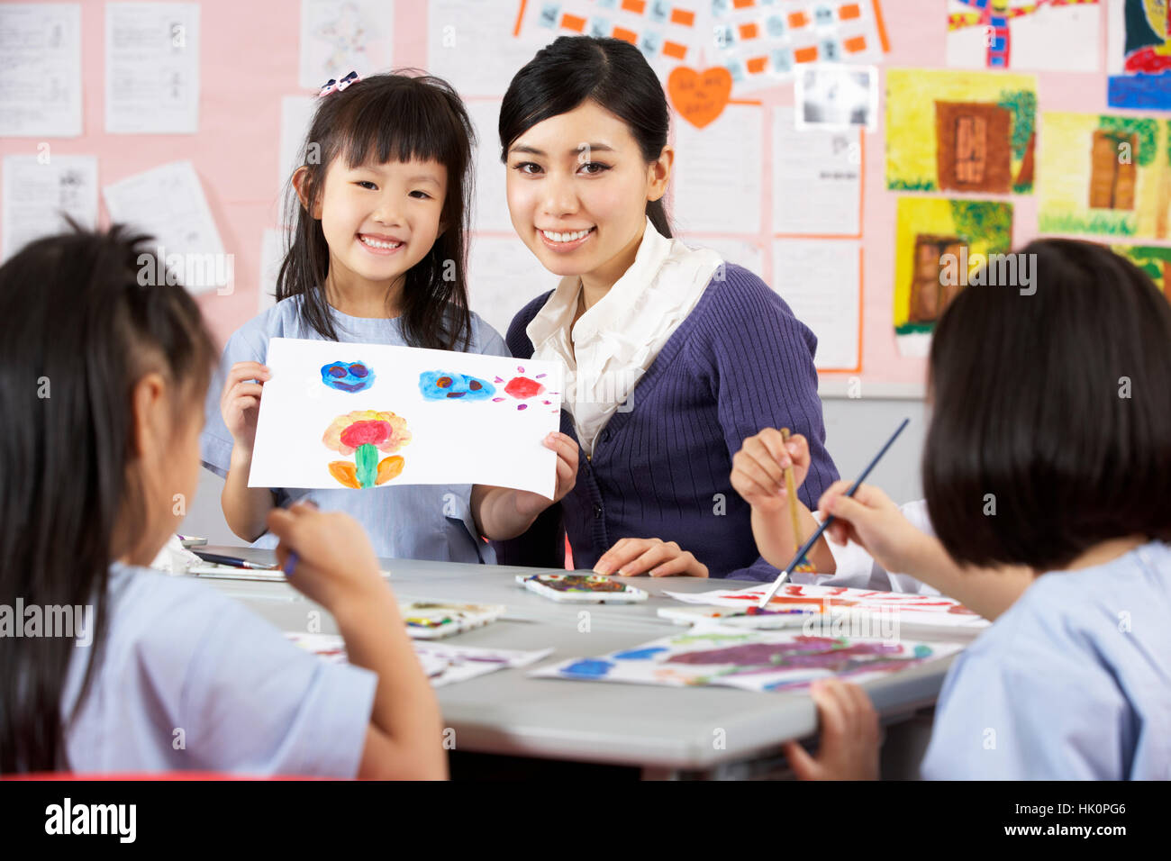 Teacher Helping Students During Art Class In Chinese School Classroom ...