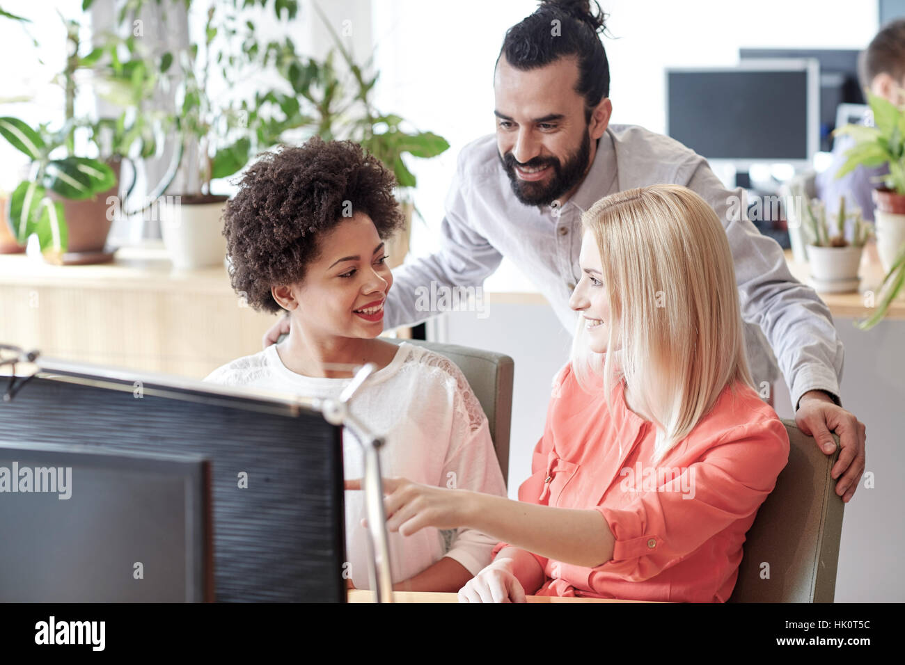 happy creative team with computer in office Stock Photo - Alamy