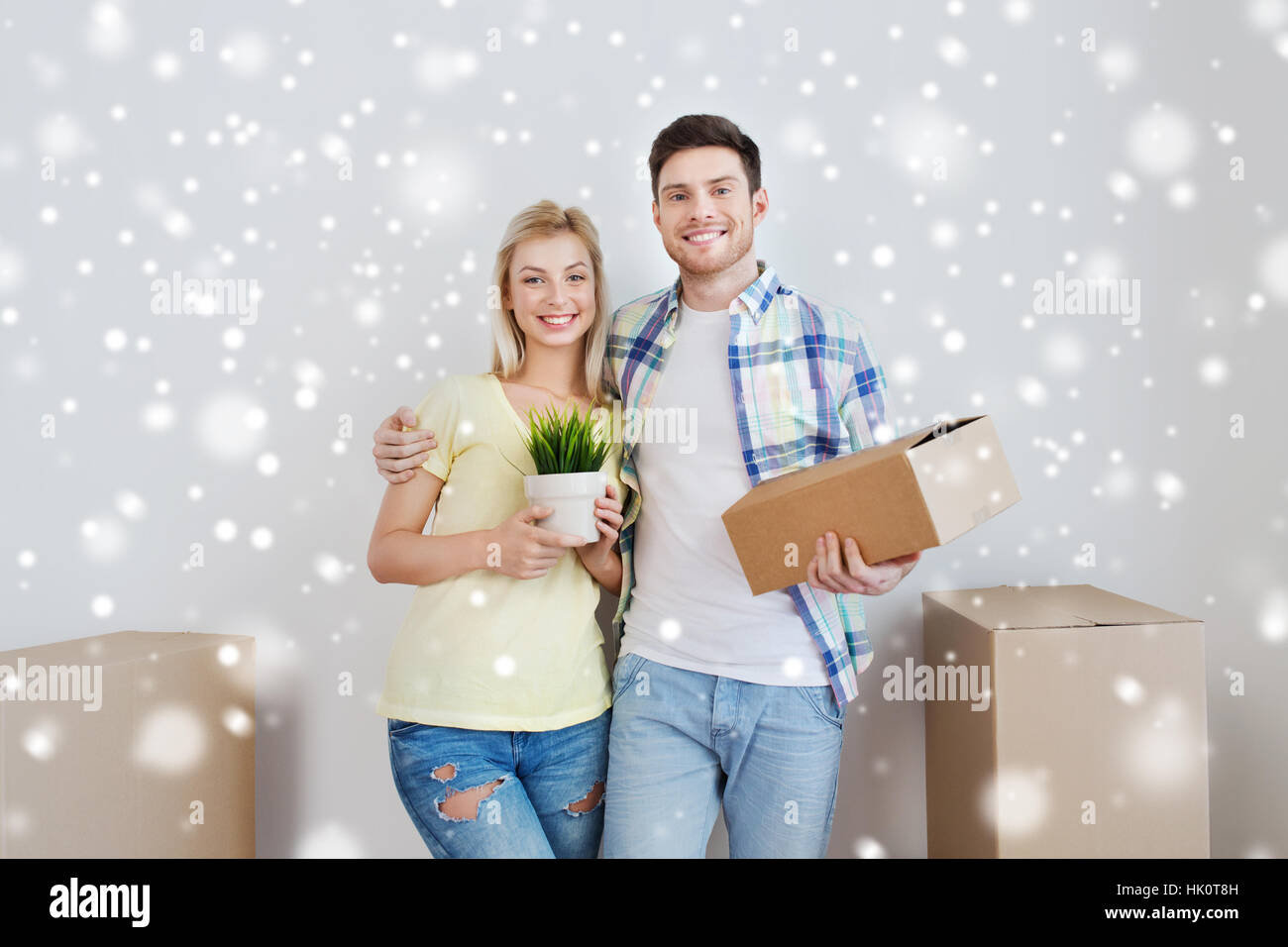 smiling couple with boxes moving to new home Stock Photo - Alamy