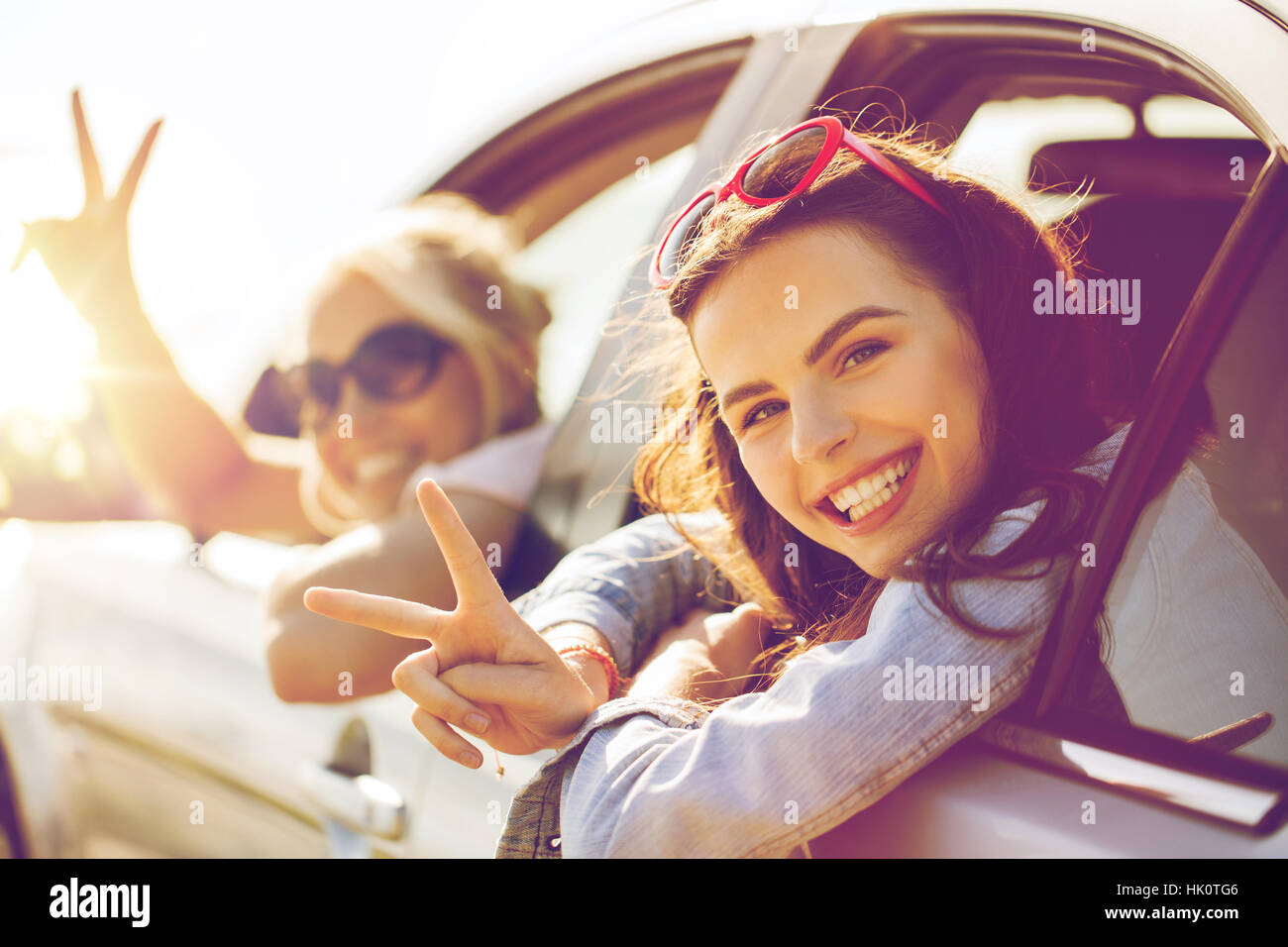 happy teenage girls or women in car at seaside Stock Photo - Alamy