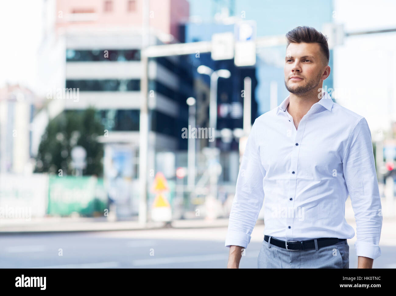 Young man walking along city street hi-res stock photography and images ...