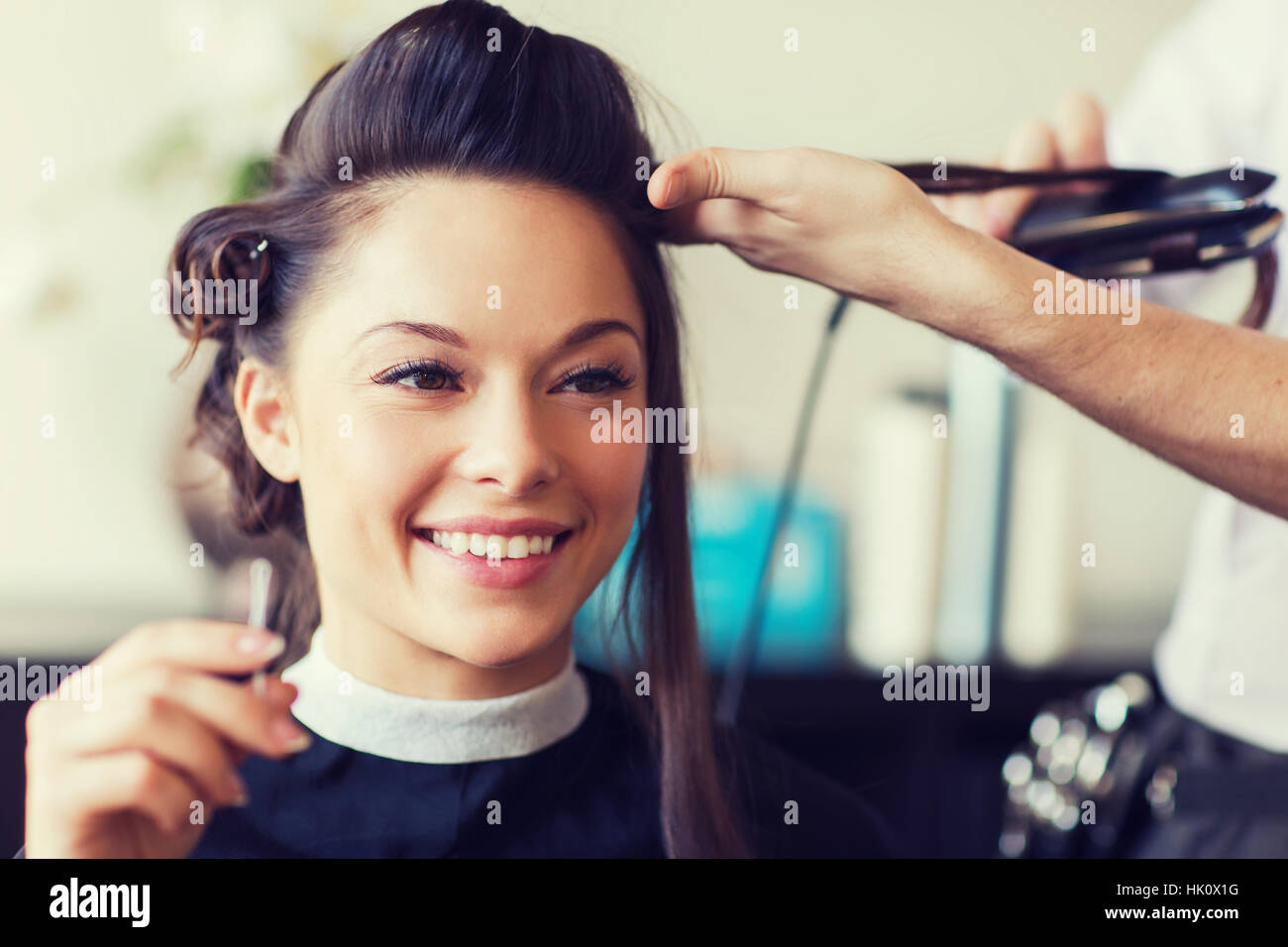 Happy Woman With Stylist Making Hairdo At Salon Stock Photo