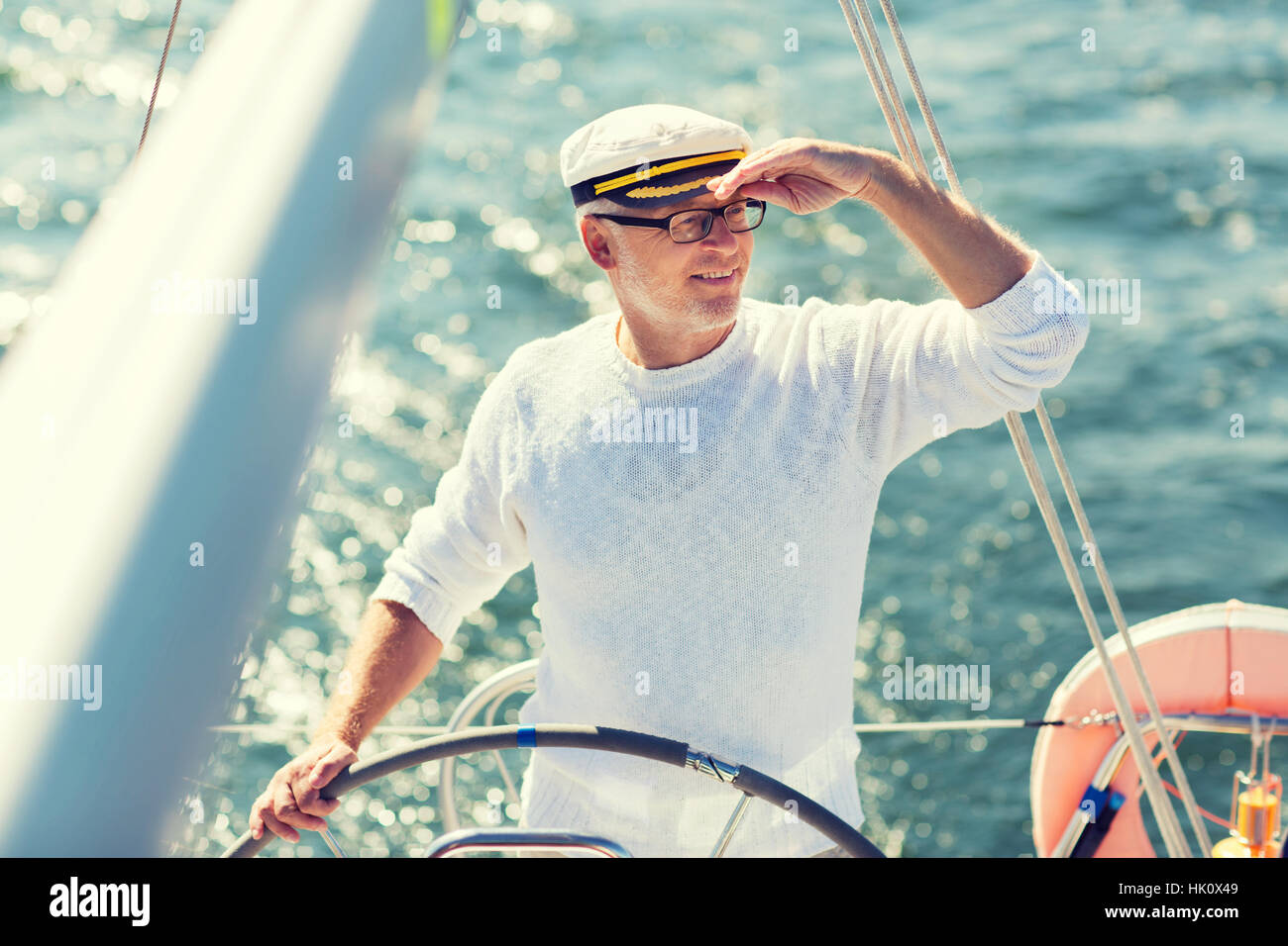 senior man at helm on boat or yacht sailing in sea Stock Photo - Alamy