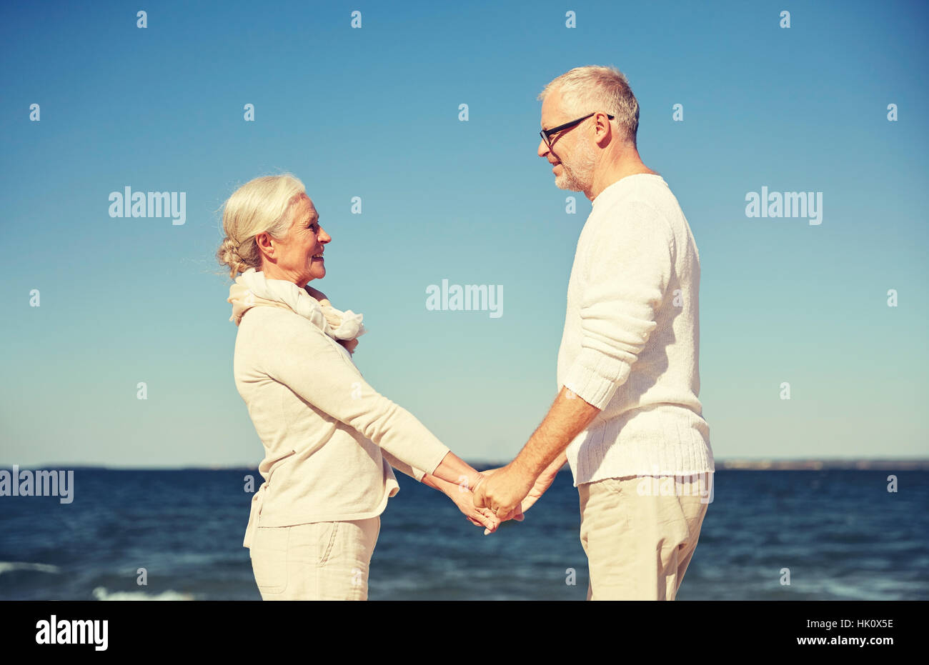 happy senior couple holding hands summer beach Stock Photo - Alamy