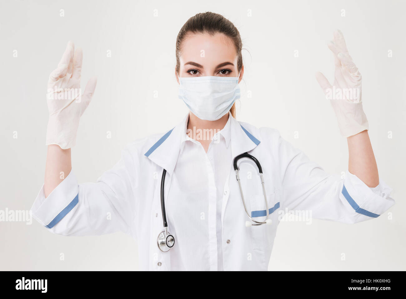 Portrait of woman doctor in mask and rubber gloves over white ...