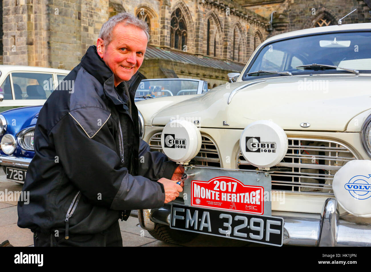 Paisley, Scotland, UK. 25th January 2017. Over 10000 spectators turned out in Paisley town centre, outside the town's famous historical abbey to cheer off the 80 entrants to this years Monte Carlo Rally.  This image is of OWEN FERRY from Paisly bolting the sign onto the front of his Volvo Amazon 1225 Credit: Findlay/Alamy Live News Stock Photo