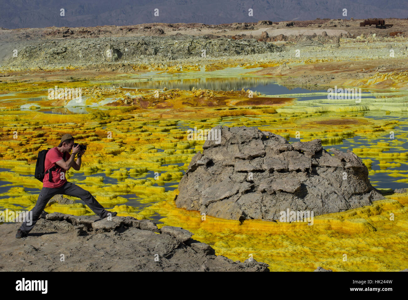 Photographer shooting the wild rock formations in the otherworldly scenery of Dalol, Ethiopia in the Danakil Depression desert Stock Photo