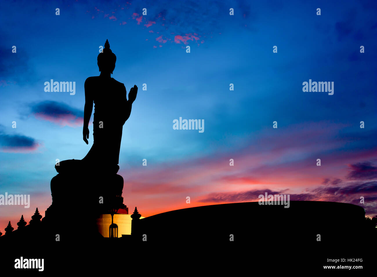 Silhouette Of The Posture Of Walking Buddhist Statue In Twilight Stock Photo