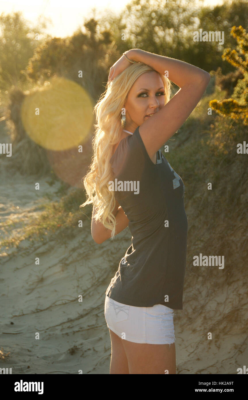 Beautiful long-haired blonde young woman in mini-skirt and top on the beach  Stock Photo - Alamy