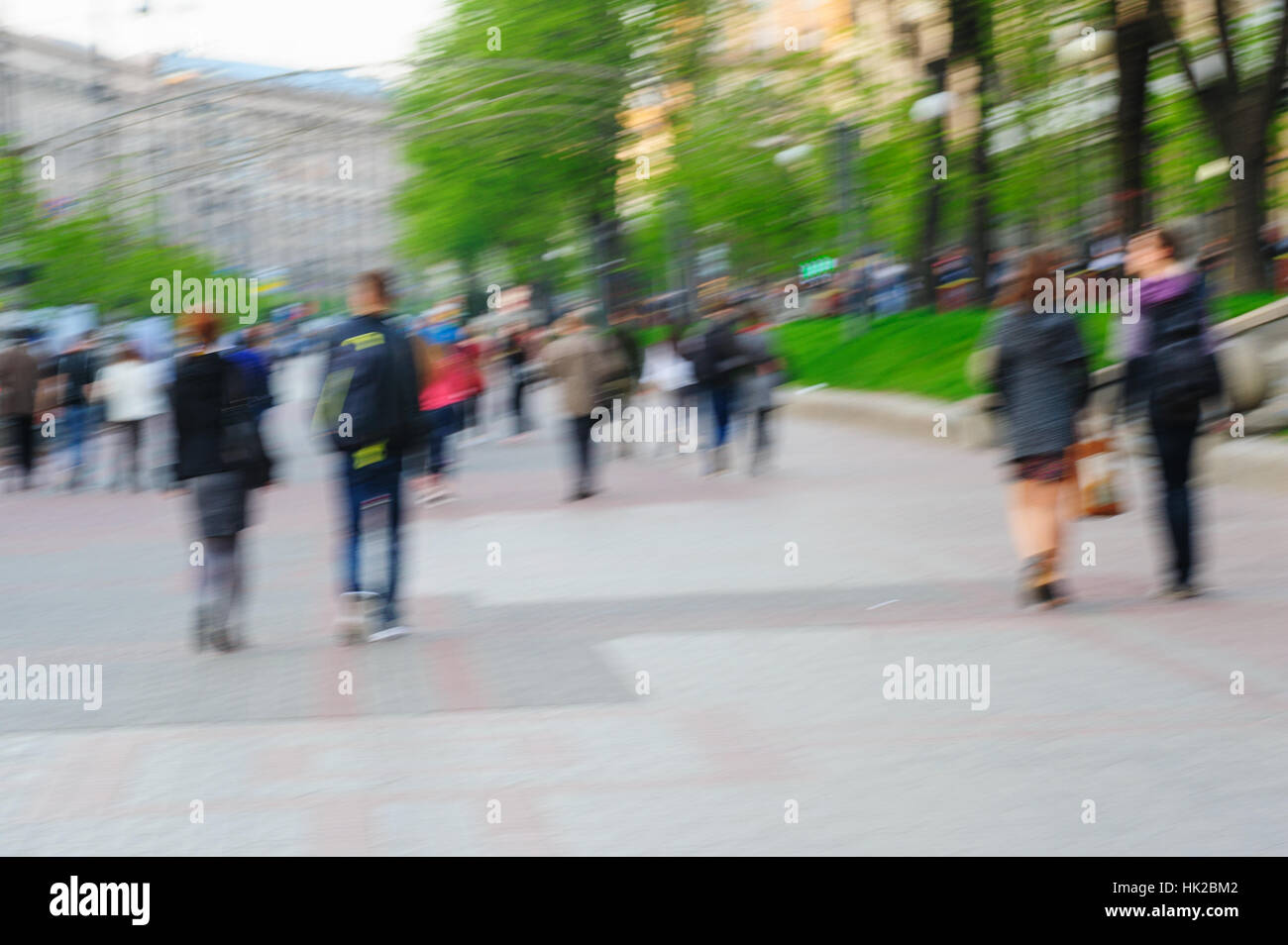 Blurred image of people walking at day in park with bokeh for background usage Stock Photo