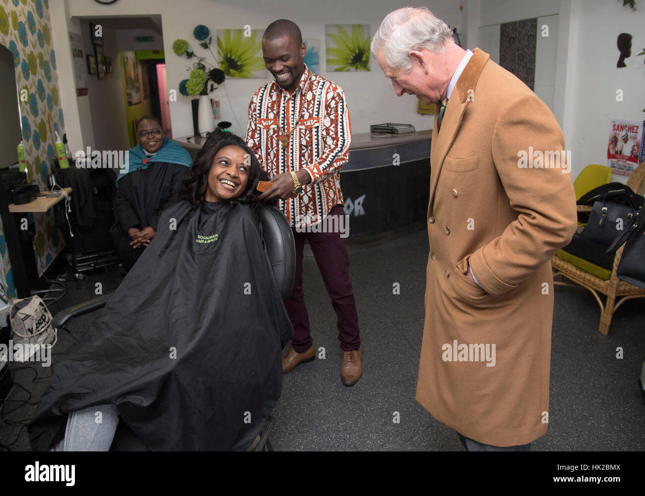 The Prince of Wales talks to staff and customers at a hairdresser's shop during a visit to