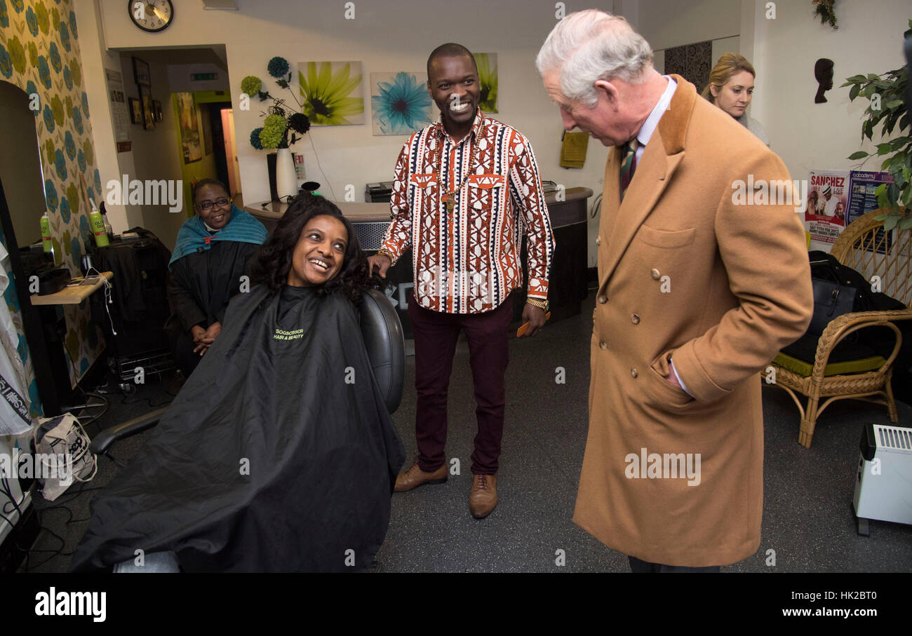The Prince of Wales talks to staff and customers at a hairdresser's shop during a visit to