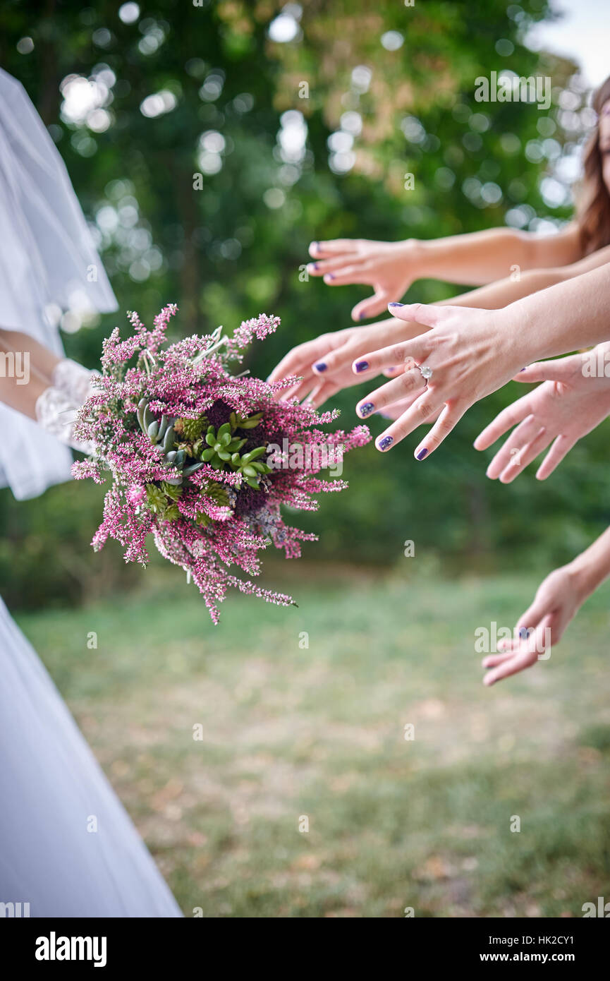 Bride Throwing Bouquet For Guests To Catch Stock Photo
