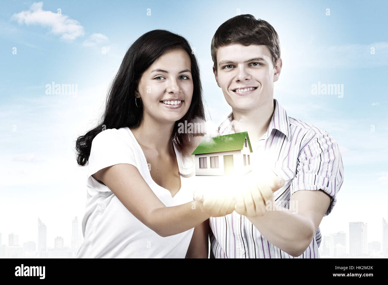 Happy young couple holding model of house on palms Stock Photo - Alamy