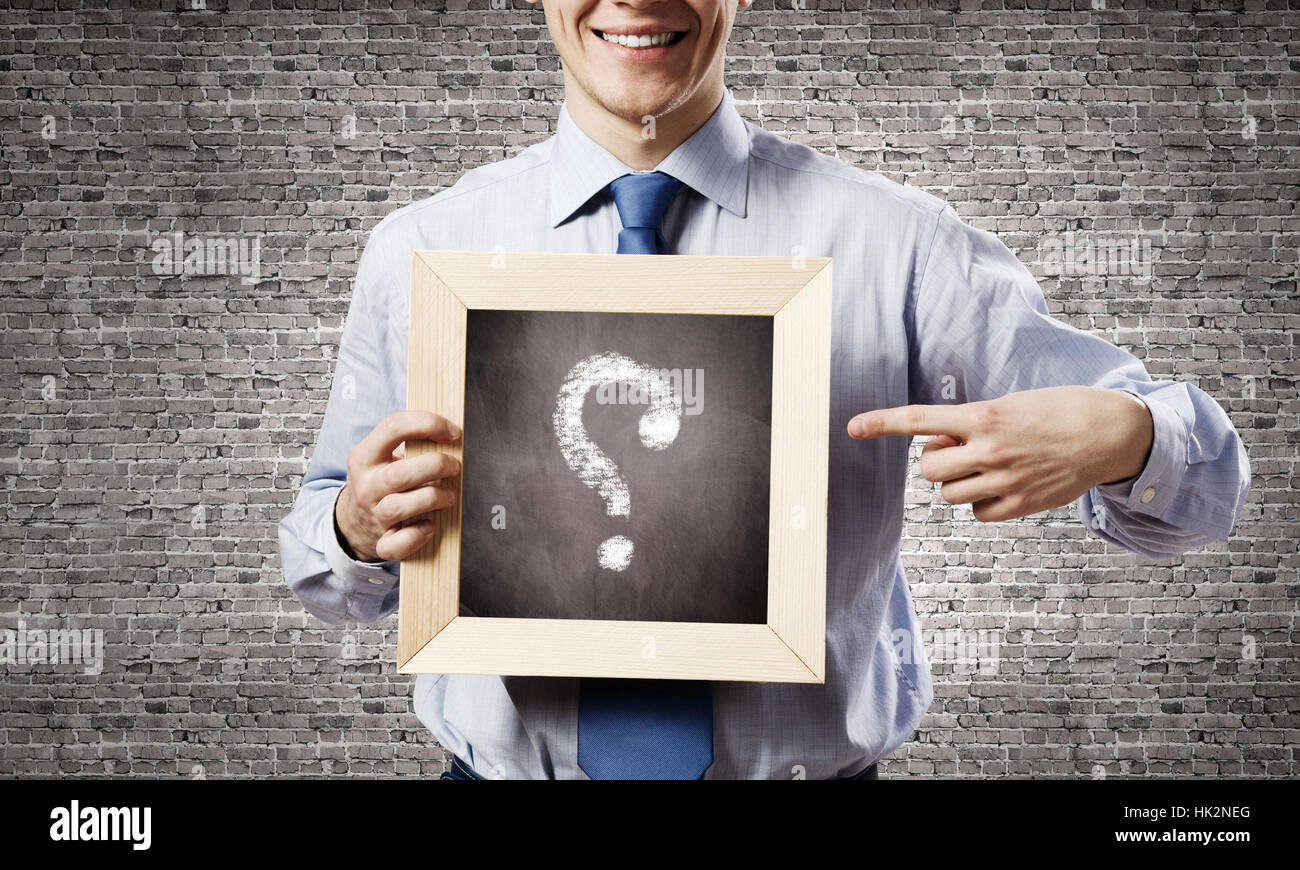 Young smiling businessman holding chalkboard with question sign Stock ...