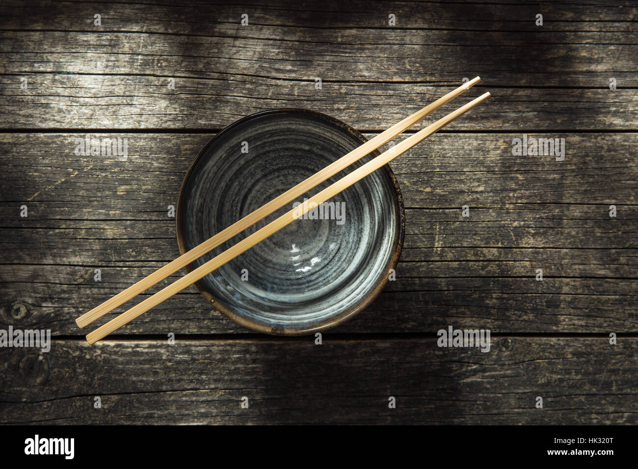 Asian bowl and chopstick on old table. Top view. Stock Photo