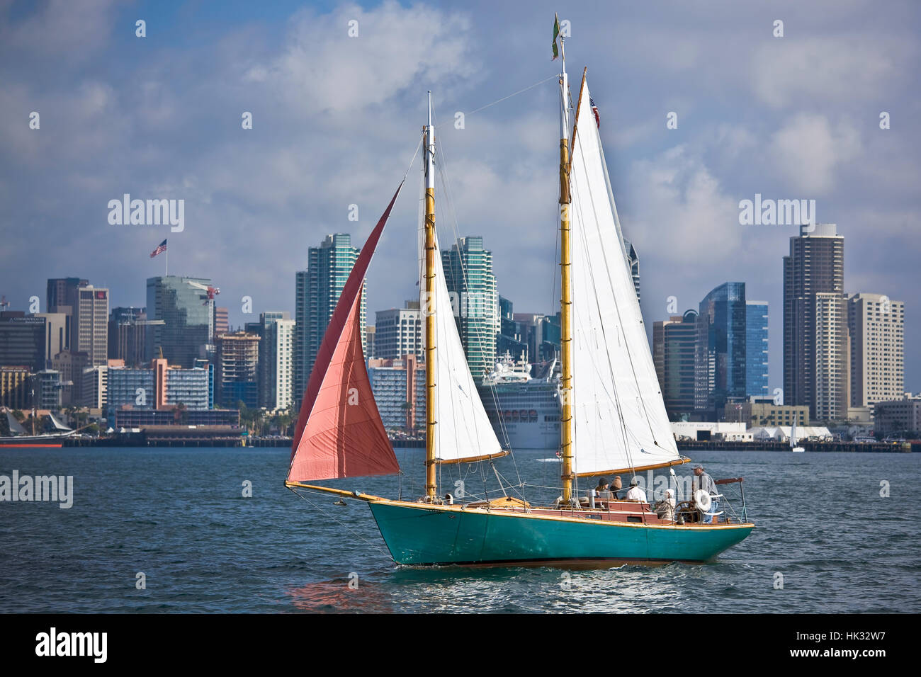 Sail boat under full sail on San Diego Bay with downtown skyline in