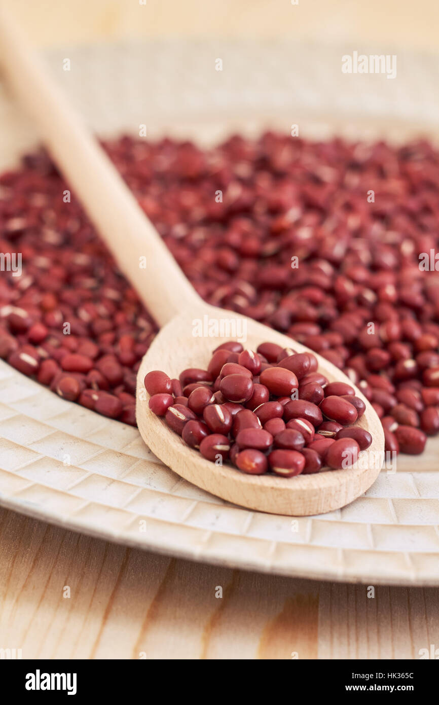 Raw uncooked adzuki red beans in wooden spoon Stock Photo