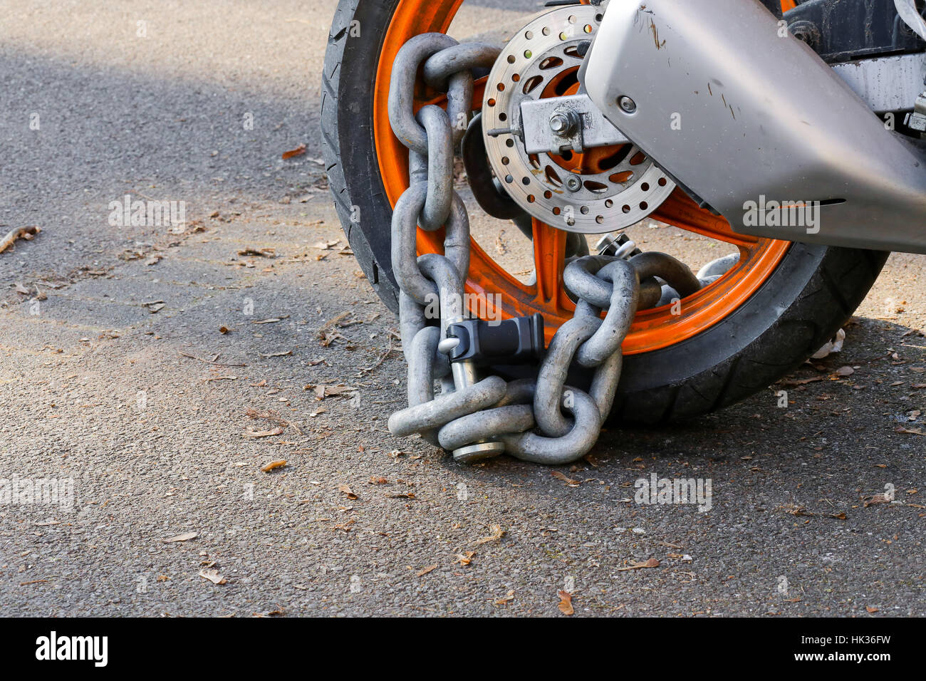 Motorcycle anti-theft chain with padlock security lock on rear wheel, protection against theft Stock Photo