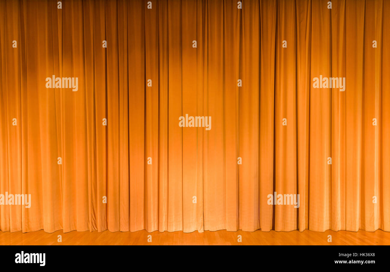 A curtain in yellow color, covering a theater stage Stock Photo