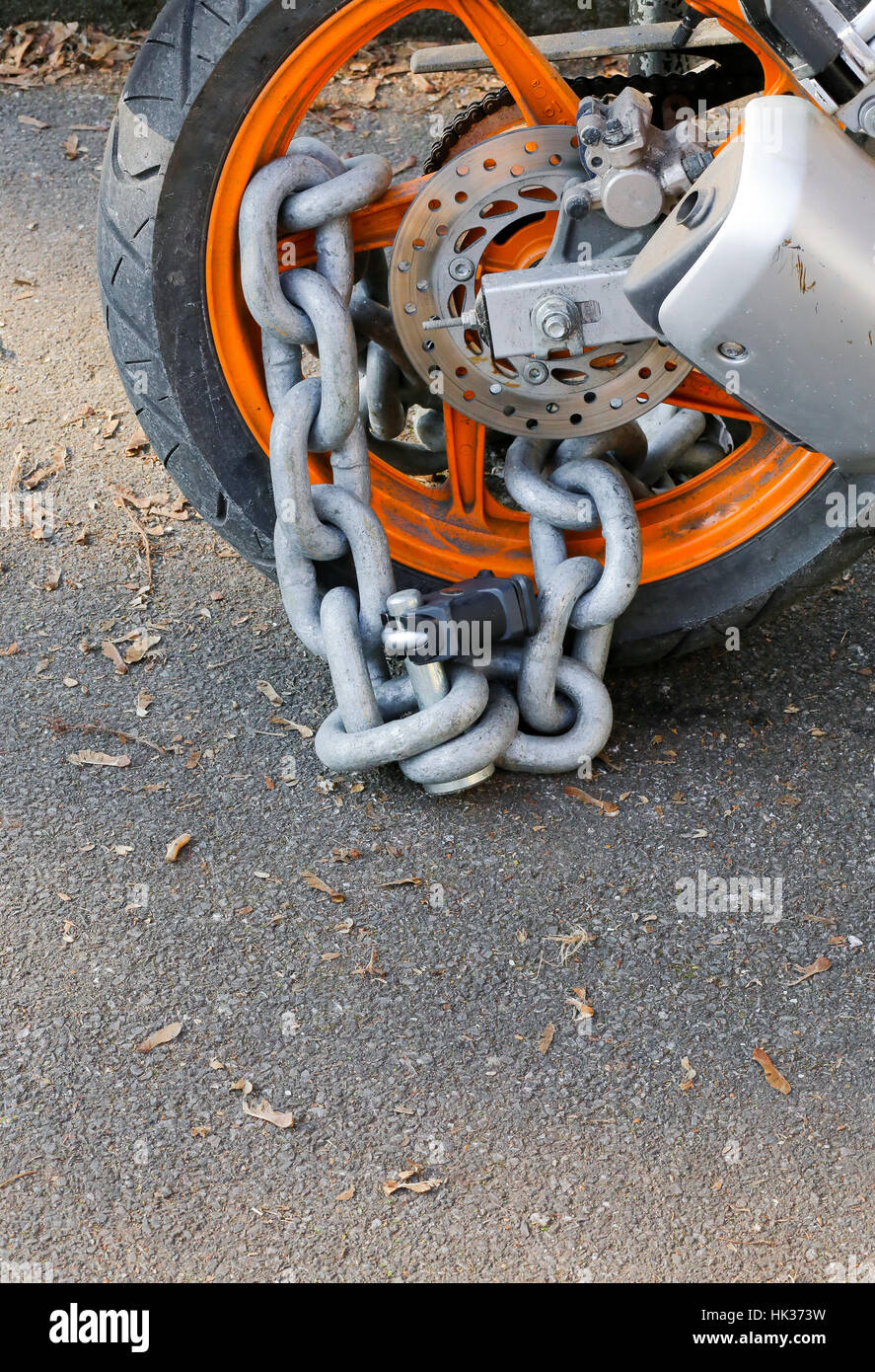 Motorcycle anti-theft chain with padlock security lock on rear wheel, protection against theft Stock Photo