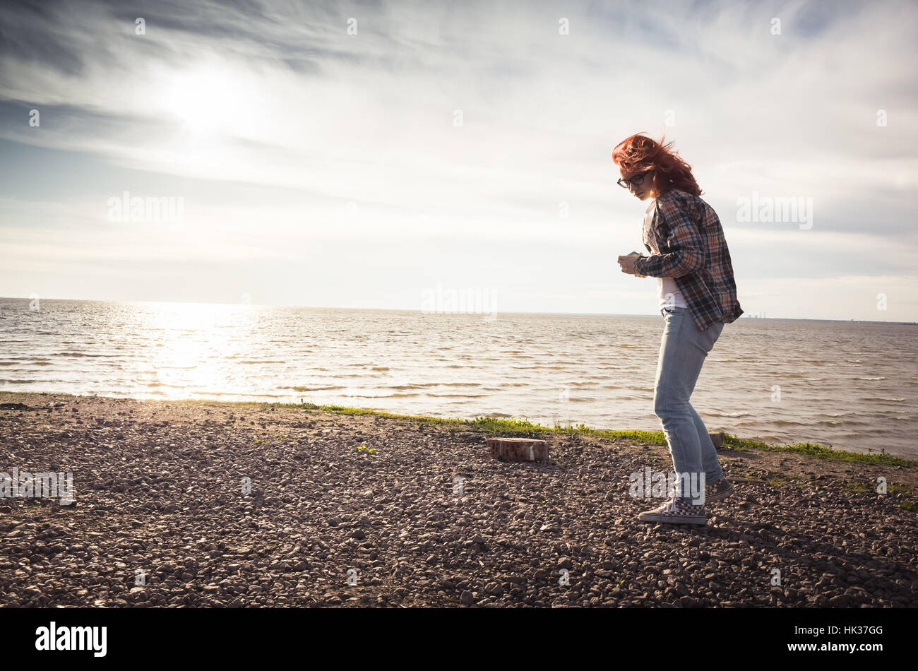 Girl walking on a sea coast, vintage tonal correction photo filter effect, old instagram style Stock Photo