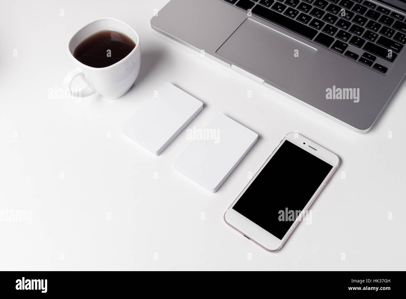 Cup With Coffee, Business Cards And Smartphone Near Laptop Stock Photo