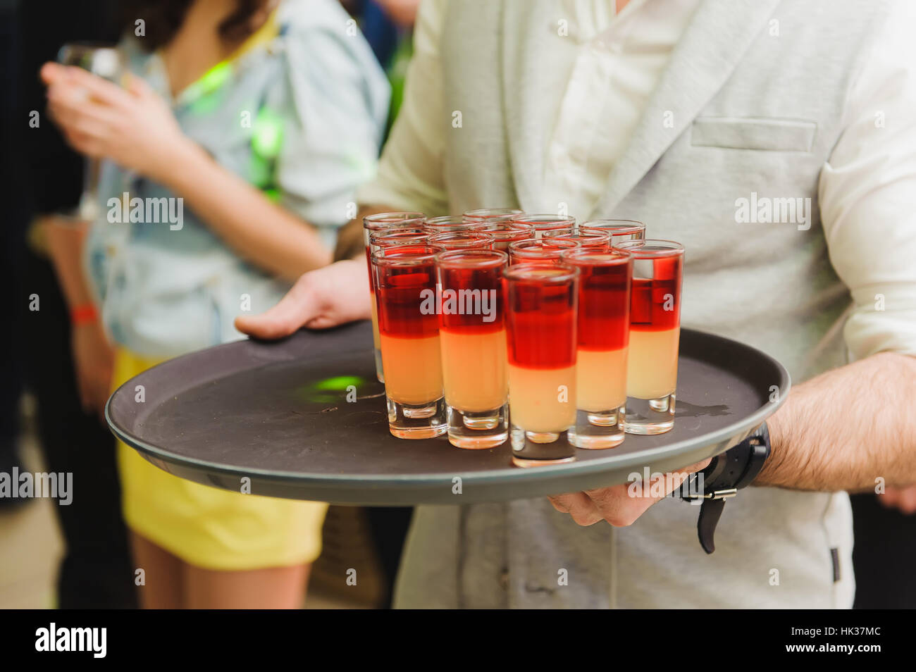 Drinking at a party. Waiter offering cocktail to guests at party, close