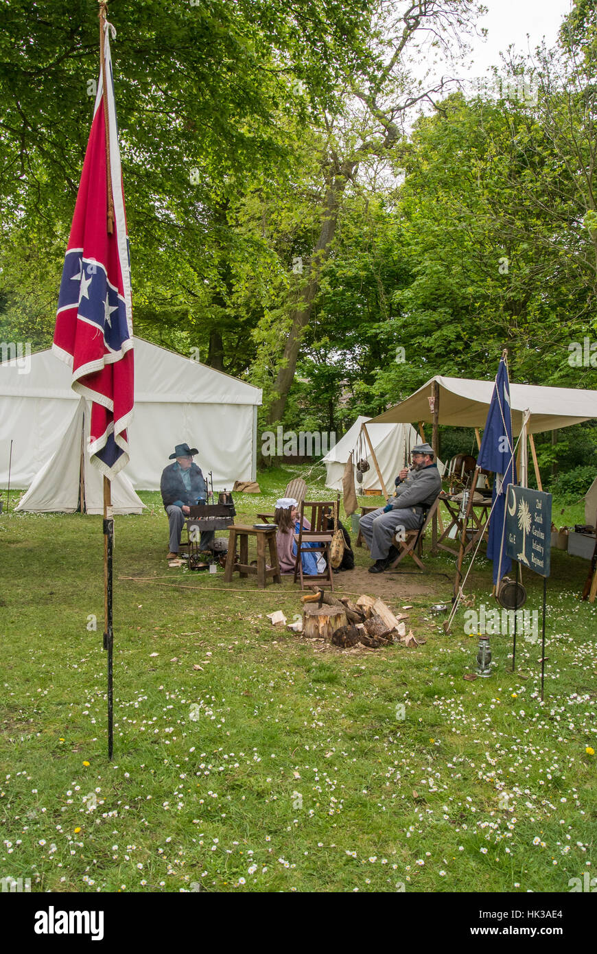 Confederate soldiers rest in their camp beside the Confederate flag at