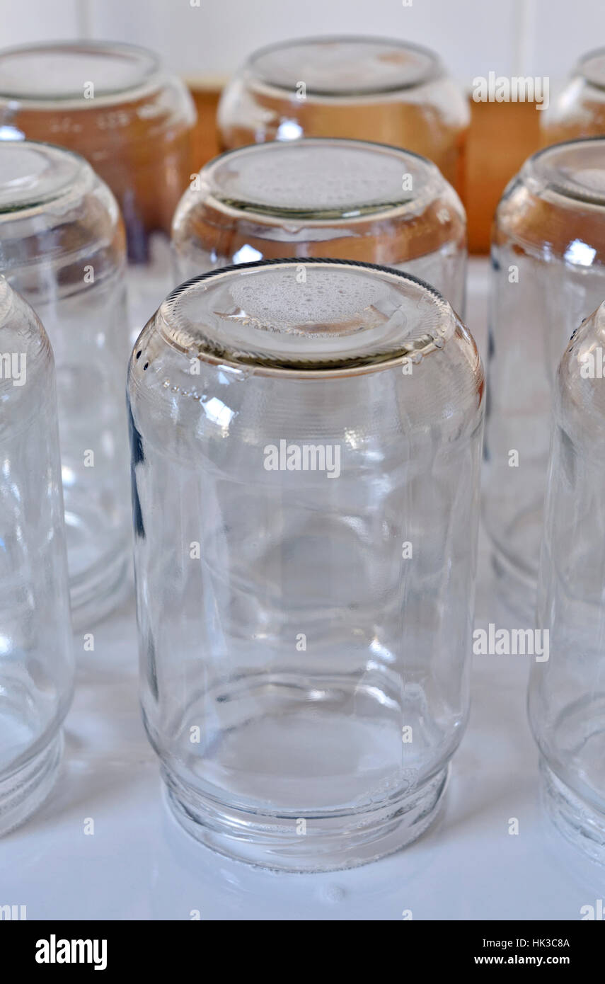 Empty glass jars upside down on draining board to be reused or recycled Stock Photo