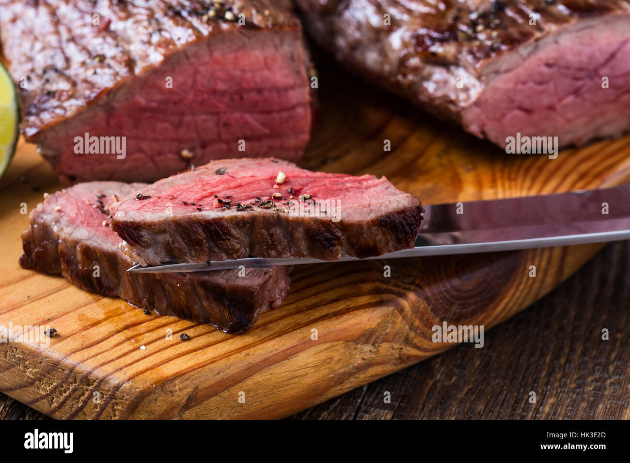 Rare roast beef sirloin with french fries on cutting board Stock Photo