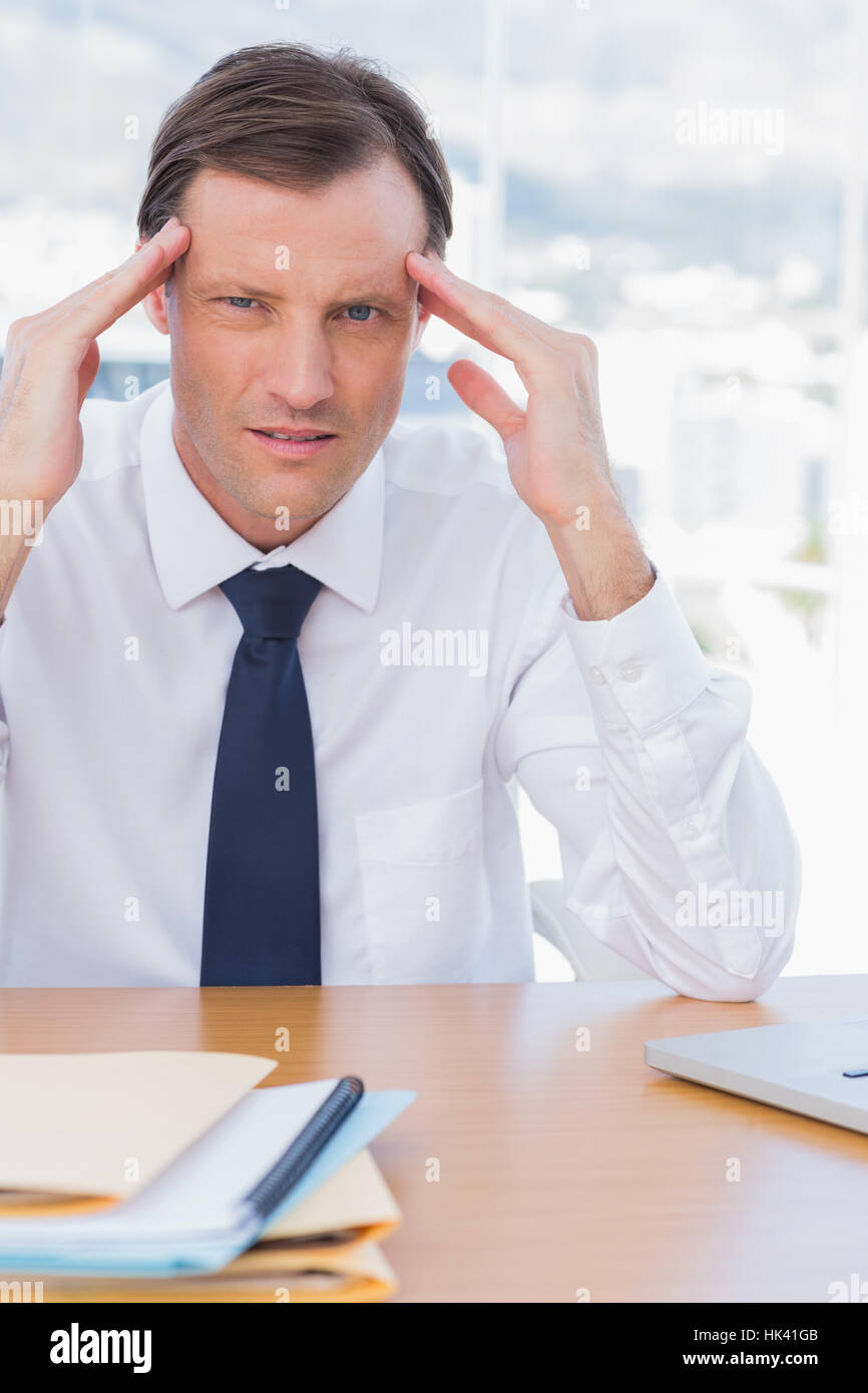 Stressed businessman holding his head in his office Stock Photo - Alamy