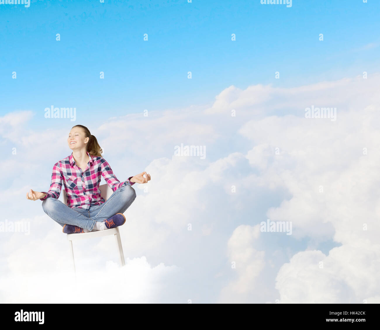 Young woman sitting on chair and meditating Stock Photo - Alamy