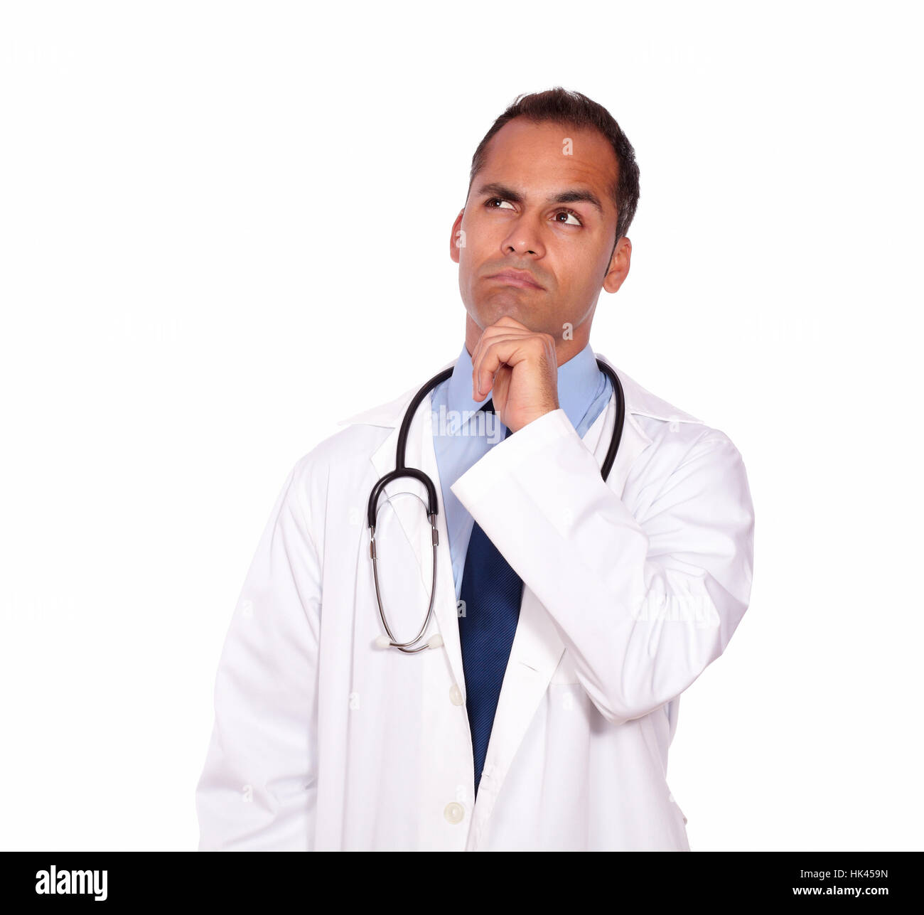 Portrait of a pensive medical doctor looking up standing in a white uniform on isolated background - copyspace Stock Photo