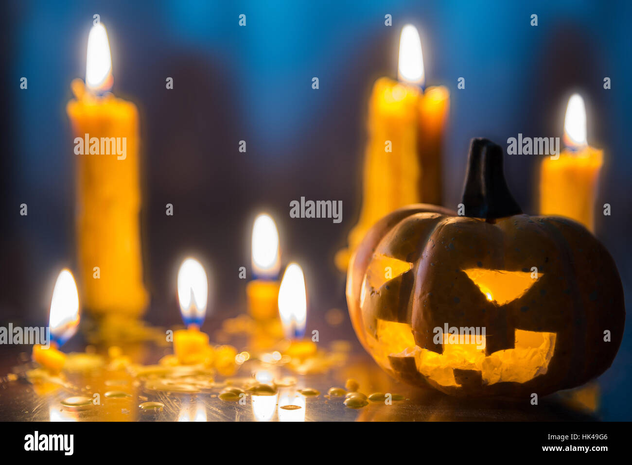 Halloween spooky Jack-O-Lantern pumpkin head with candles decoration at night background, selective focus Stock Photo